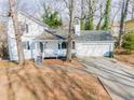 Charming two-story home featuring a covered front porch and a well-maintained yard with mature trees and a two-car garage at 3661 Silver Leaf Sw Ln, Marietta, GA 30008