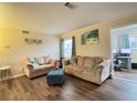 Cozy living room with hardwood floors, neutral-toned furniture, and natural light streaming in through a window at 62 Place Fontaine, Lithonia, GA 30038