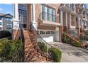 Charming townhome with a two-car garage, brick stairs and iron railings leading to the front door at 1029 Emory Parc Pl, Decatur, GA 30033