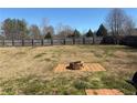 Spacious backyard featuring a fire pit area surrounded by a wooden fence providing privacy and a dedicated space for outdoor gatherings at 1073 Crown Landing Pkwy, Mcdonough, GA 30252