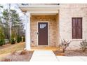 Inviting entryway with a stylish brown door, brick facade, and manicured landscaping at 4700 Blake Loop, Atlanta, GA 30349