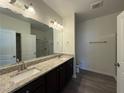 Spacious main bathroom featuring a dual-sink vanity with granite countertops, shower, and wood-look flooring at 8620 Blair Ct, Douglasville, GA 30134