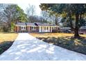 Cozy brick home with a well-manicured lawn, front porch, and new concrete driveway at 1523 Vancouver Dr, Tucker, GA 30084