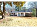 Landscaped front yard featuring a brick and siding home with a bright blue door and a cozy front porch at 1523 Vancouver Dr, Tucker, GA 30084