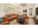 Bright living room with wood floors, an orange sofa, an orange armchair, and a ceiling fan at 2302 Abner Nw Pl, Atlanta, GA 30318