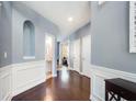 Welcoming foyer with hardwood floors, wainscoting, and arched doorway at 599 Jefferson Chase St, Atlanta, GA 30354