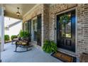 Inviting front porch with rocking chairs, decorative wreath, and detailed brickwork at 8220 Majors Ridge Way, Cumming, GA 30041