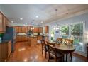 Spacious kitchen with wooden cabinets, granite countertops, stainless steel appliances, and an adjacent dining area at 8220 Majors Ridge Way, Cumming, GA 30041