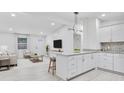 Open-concept living area with a modern kitchen island, light wood floors, and ample natural light at 125 Glenrose Sw Cir, Atlanta, GA 30354