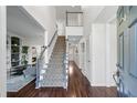 Inviting home foyer with hardwood floors, a staircase, and views into the living spaces at 565 Ashvale Overlook, Alpharetta, GA 30005