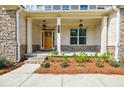 Inviting front porch with stone accents, manicured landscaping, and a warm, wood front door at 783 Phil Haven Ln, Kennesaw, GA 30152