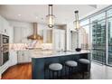 Modern kitchen with marble countertops, stainless steel appliances, and island seating at 1065 Peachtree Ne St # 3005, Atlanta, GA 30309