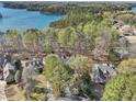 Aerial view of the neighborhood with lush trees and a serene lake backdrop at 6030 Chimney Springs Rd, Buford, GA 30518