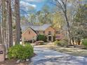Beautiful brick home with a long driveway and lush landscaping surrounded by mature trees at 6030 Chimney Springs Rd, Buford, GA 30518