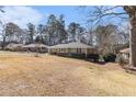 Lovely single-story home features a green exterior, complemented by mature trees and a spacious front yard at 2100 Shady Ln, Tucker, GA 30084