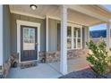 Inviting front porch with stone accents, white columns, and a charming welcome mat at 50 Crabapple Ridge Dr, Oxford, GA 30054