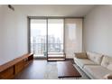 Bright living room with hardwood floors, comfortable sofa, area rug and a large window at 1080 Peachtree St # 2116, Atlanta, GA 30309