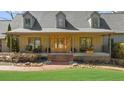 The front porch of this home features a brick walkway, wood double doors, and outdoor seating at 7565 Heard Rd, Cumming, GA 30041