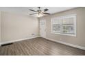 Bright living room with wood-look flooring, ceiling fan and lots of natural light from the window at 542 Oak Hills Sw Rd, Mableton, GA 30126