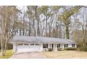 Charming single-story home with an attached two-car garage and a well-maintained front yard at 566 Sugar Valley Lane, Conyers, GA 30094