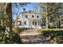A two-story home with a prominent front porch framed by mature trees and established landscaping at 818 Springdale Ne Rd, Atlanta, GA 30306