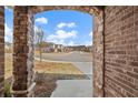 View of a quiet street lined with homes from the brick-lined front porch at 1246 Allspice Way, Lawrenceville, GA 30045