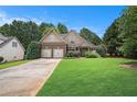 Beautiful two-story home with lush green lawn and brick and siding exterior at 8000 Abington Dr, Locust Grove, GA 30248
