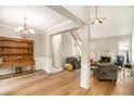 Bright, spacious living room with hardwood floors, fireplace, chandelier and open staircase at 8000 Abington Dr, Locust Grove, GA 30248