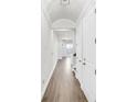 Bright hallway with hardwood flooring, white trim, and an arched doorway leading to the living spaces at 116 Via Roma, Woodstock, GA 30188