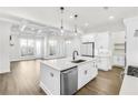 Modern kitchen features white cabinets, quartz countertops, stainless steel appliances, and a spacious island at 116 Via Roma, Woodstock, GA 30188