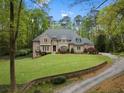 Beautifully landscaped front yard with a stone retaining wall and winding driveway at 581 Fairfield Nw Rd, Atlanta, GA 30327