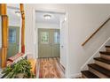 Bright foyer featuring a staircase, wood-look floors, and view of the front door at 9635 Loblolly Ln, Roswell, GA 30075