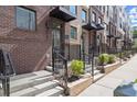 Brick townhome exterior featuring individual entrances with stoops, wrought iron railings, and manicured landscaping at 201 New St # 2207-1, Decatur, GA 30030