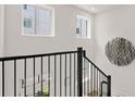 Bright staircase landing featuring a black railing and two windows at 201 New St # 2207-113, Decatur, GA 30030