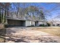 View of the home's exterior featuring a large driveway and a convenient carport area at 3759 Rosemary Se Ln, Conyers, GA 30013