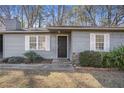 Charming home exterior features a black front door, complemented by white window shutters at 3759 Rosemary Se Ln, Conyers, GA 30013