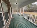 A cozy, covered porch features a stone wall and painted wooden flooring at 5559 John Burruss Rd, Cumming, GA 30040