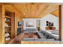 Living room with wood paneled walls, beamed ceiling, fireplace, and comfortable sectional seating at 566 Hickory Hills Ct, Stone Mountain, GA 30083