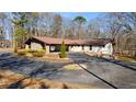 Lovely home with a porte-cochere, stone details, and mature landscaping on a sunny day at 2499 E Maddox Rd, Buford, GA 30519