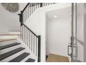 Elegant staircase featuring dark wood steps, black railings, and white walls at 201 New St # 2301, Decatur, GA 30030