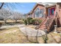 Attractive brick facade, complemented by blossoming trees and inviting steps leading to the red front door at 2101 Oakleaf Ln, Lithia Springs, GA 30122