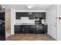 Well-lit kitchen showcasing sleek black appliances, cabinets, and hardwood floors at 3063 Kerr Dr, Decatur, GA 30034