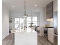 Well-lit kitchen featuring stainless steel appliances, a large island with seating and pendant lights at 201 New St # 2305-1, Decatur, GA 30030