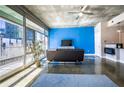Bright living room with concrete floors, large windows, and a modern sofa facing a vibrant blue wall at 845 Spring Nw St # 322, Atlanta, GA 30308