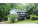 A charming two-story home with a covered porch, surrounded by lush greenery and mature trees at 3875 Wintergreen Ct, Marietta, GA 30062