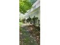 Side view of a two-story house with a long porch and a sidewalk surrounded by plants and greenery at 3875 Wintergreen Ct, Marietta, GA 30062