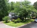 Exterior shot of a two-story home with a manicured lawn, surrounded by large trees in a neighborhood setting at 3875 Wintergreen Ct, Marietta, GA 30062