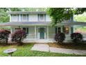 Charming front porch of this light blue two-story home, featuring a well-manicured yard and stone bird bath at 3875 Wintergreen Ct, Marietta, GA 30062