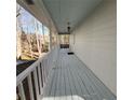 Long, covered porch with a white railing and a swing, offering a relaxing outdoor space at 3875 Wintergreen Ct, Marietta, GA 30062