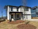 Exterior view of a white two-story home with a two-car garage, covered porch and manicured lawn at 2108 Boxwood Circle Se, Conyers, GA 30094